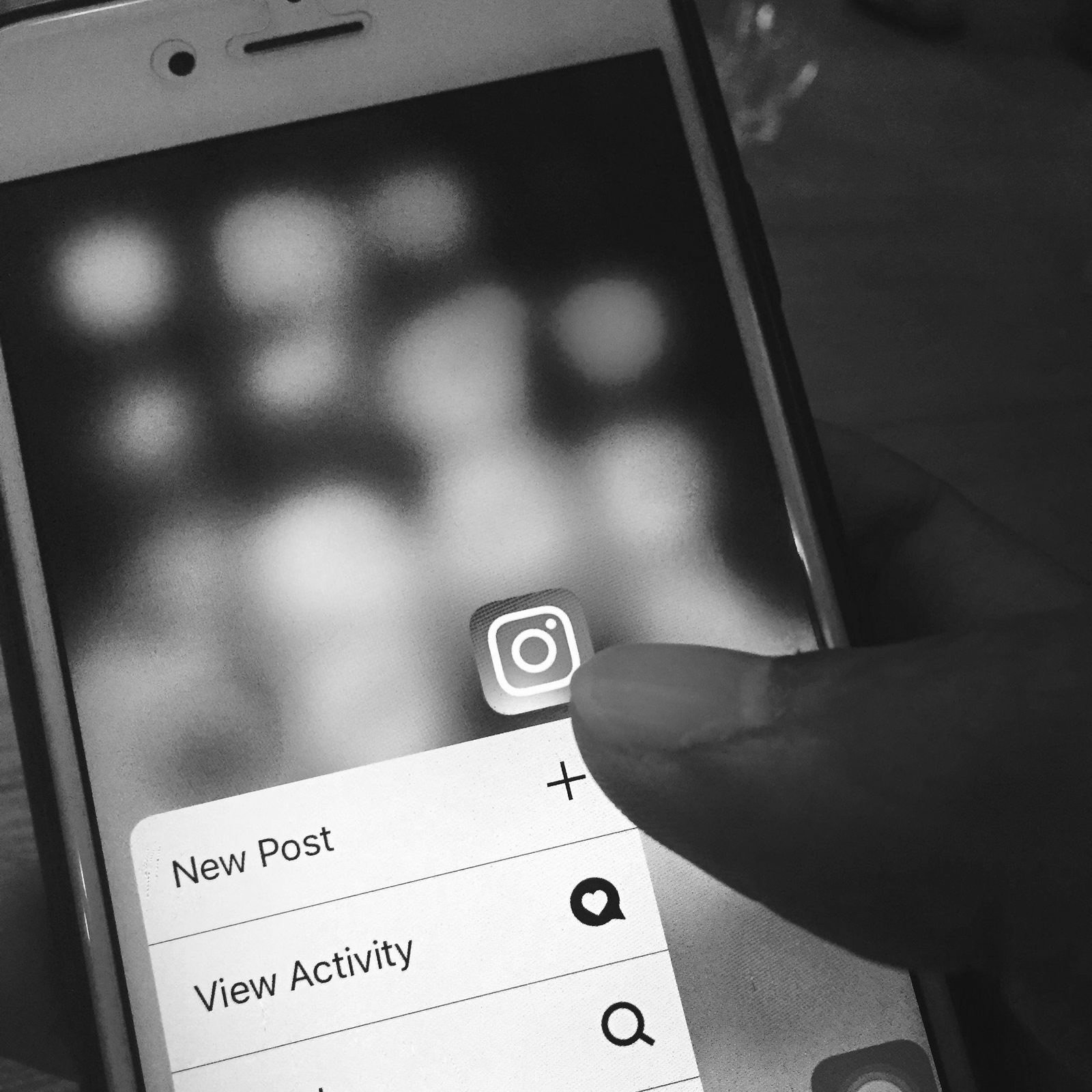A finger opening the Instagram app on a phone
