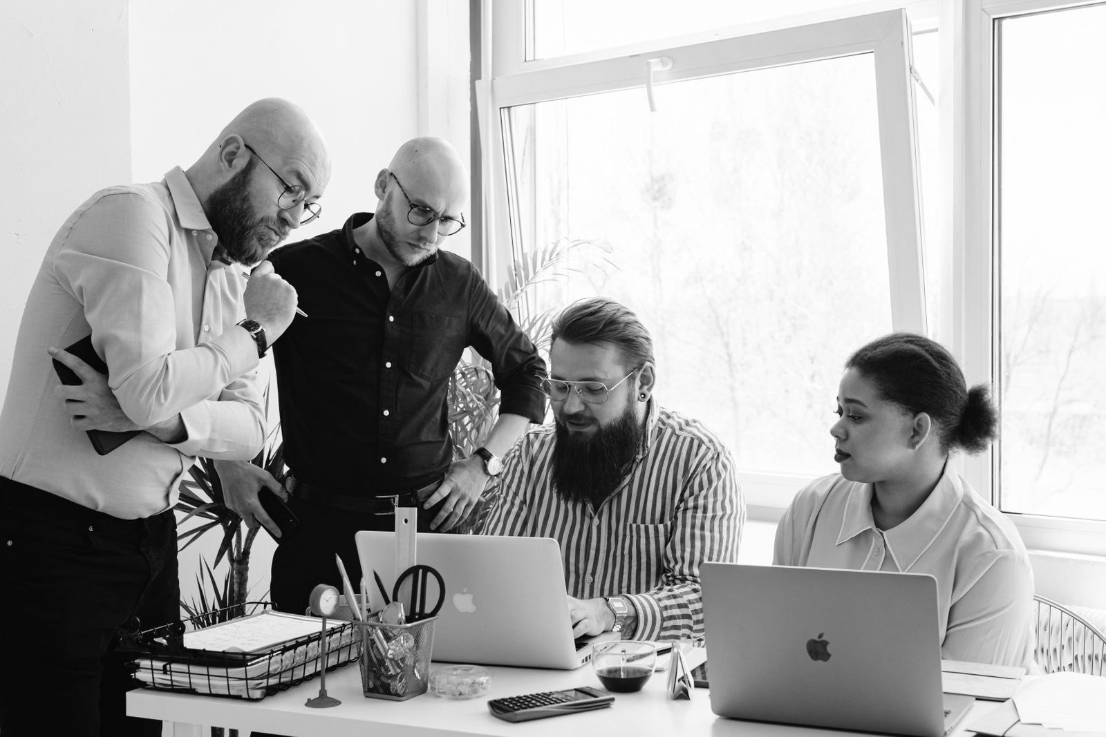 A team reviewing work together on laptops